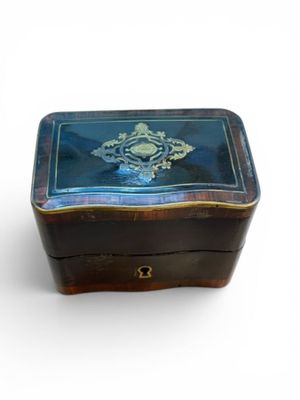 une petite boîte bleue ornée d'un motif doré