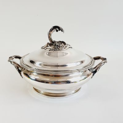 an antique silverplated bowl with a lid on a white surface