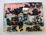 a box of assorted buttons on a white surface