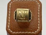 a close up of a brown leather box with a gold ring on it