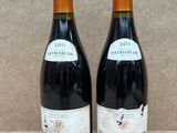 deux bouteilles de vin posées sur une table l'une à côté de l'autre