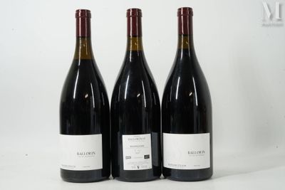 trois bouteilles de vin rouge sont alignées sur une surface blanche