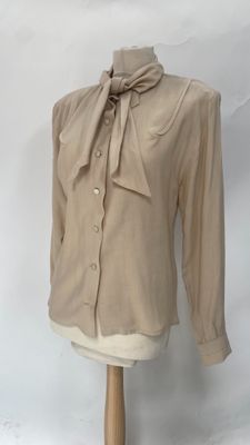 beige shirt with a bow on the neck on a mannequin stand