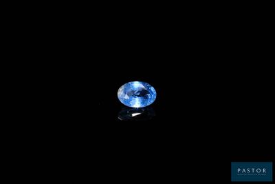 a close up of a blue sapphire on a black surface