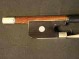 a violin bow with a wooden handle on a black surface
