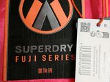 a pink backpack with a black and orange logo on it