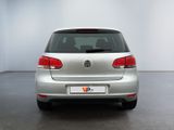 the back end of a silver vw golf parked in a white room