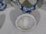 une table sur laquelle sont posées des tasses et des soucoupes en porcelaine bleue et blanche