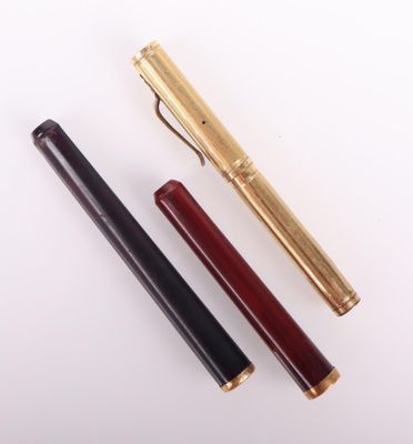 deux stylos et un stylo posés sur une surface blanche