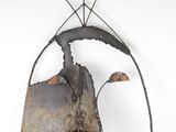 rusty metal sculpture of a bird on a branch on a white background