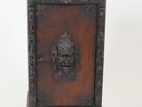 a small wooden cabinet with a lion head on it