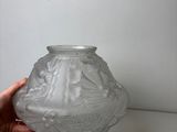 a person holding a glass vase on a table