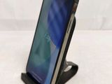 a close up of a cell phone on a stand on a white surface
