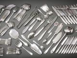 a lot of silverware on a table with spoons and forks