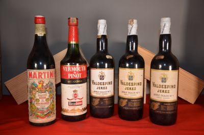 several bottles of wine are lined up on a red table