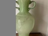 un vase vert posé sur une table en bois