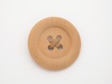 a wooden button with a cross on it on a white surface