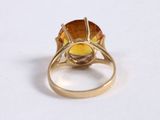 a close up of a ring with a yellow stone in it