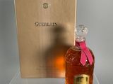 a bottle of guerlain on a clear table