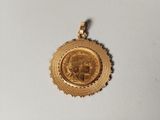 gros plan d'une médaille d'or sur une surface blanche