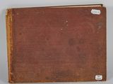 an old book sitting on top of a table next to a white wall