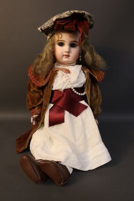 a doll that is sitting on the ground wearing a hat