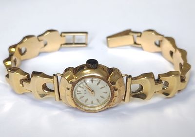 une image représentant une montre en or avec un cadran blanc et un bracelet en or