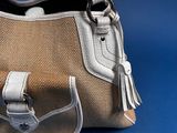 someone is holding a purse with a handle on a blue background