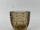 une image représentant un verre en verre brun posé sur une surface blanche