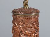 a metal container with a bird on it on a wooden table
