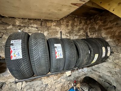 Plusieurs pneus sont empilés sur une étagère dans un garage
