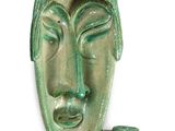 une image représentant un masque en céramique verte sur fond blanc