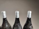 three bottles of wine that are sitting on a table