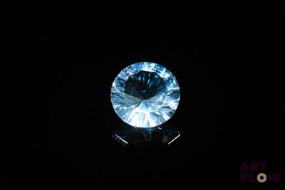 a close up of a blue diamond on a black surface