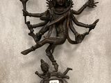 statue en bronze du dieu hindou Shiva, assis sur un rocher et tenant un bâton