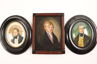 three framed portraits of two men and a woman on a wall