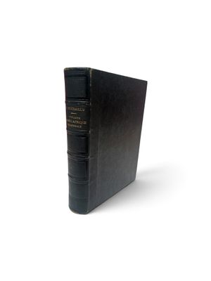 un vieux livre noir posé sur une surface blanche