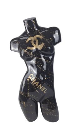 black and gold chanel statue of a woman with a chanel logo on her chest