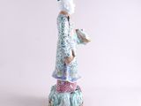 an image of a figurine of a woman in a blue dress and hat