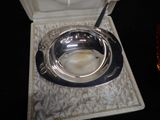 a silver plate with a spoon in it sitting on a tray