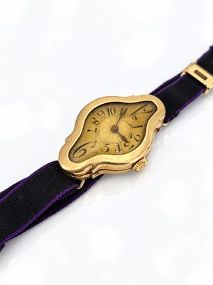 une montre-bracelet en or avec un bracelet violet sur un fond blanc