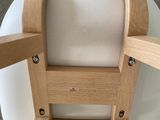 a wooden chair with a white cushion on top of it
