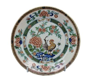 une assiette décorée d'un coq et de fleurs