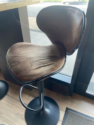 une chaise marron posée devant une fenêtre