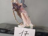 une figurine représentant une fée assise sur une étagère