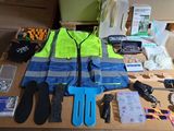 une table sur laquelle se trouvent de nombreux objets, notamment un gilet de sécurité, des gants, des ciseaux et d'autres objets
