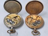 two different types of pocket watches on the table