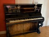 a piano in the corner of a room with a rug on the floor