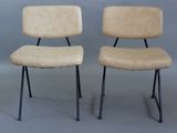 pair of mid century chairs with black legs and a tan upholstered upholstered seat