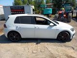 the white volkswagen golf gtr is parked in a lot